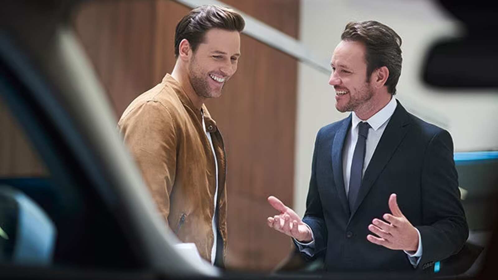 Male professional marketer explaining about car details at retailer outlet